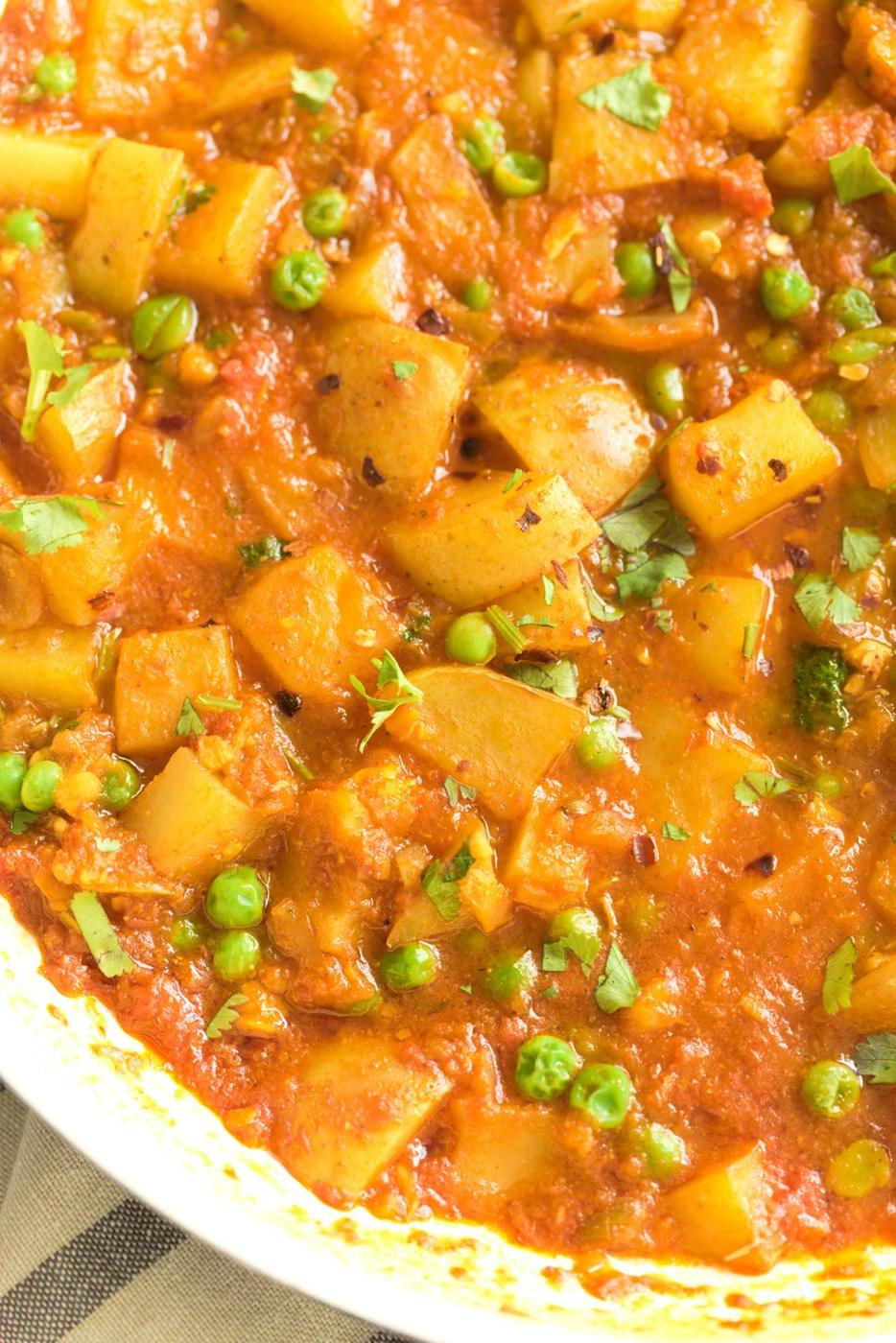 close-up of a skillet with healthy vegan Indian aloo matar simmering