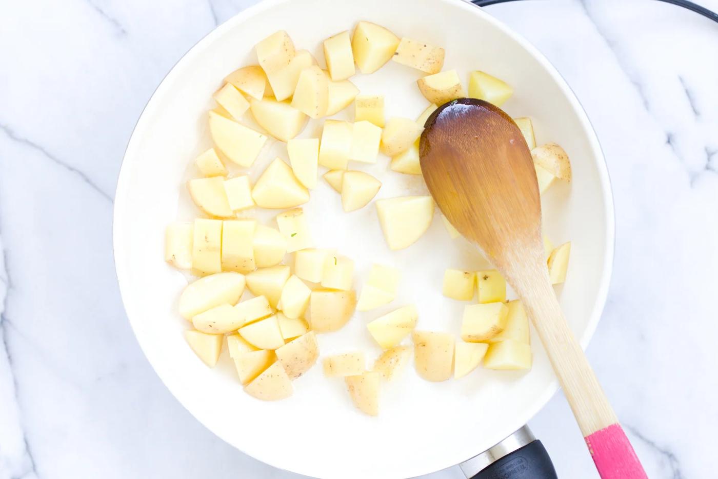 potato cubes being sauteed in a skillet