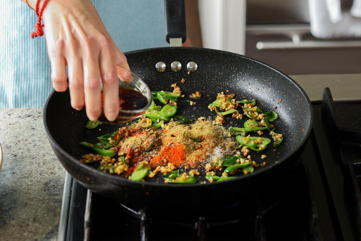 adding ground spices and sauces to the pan