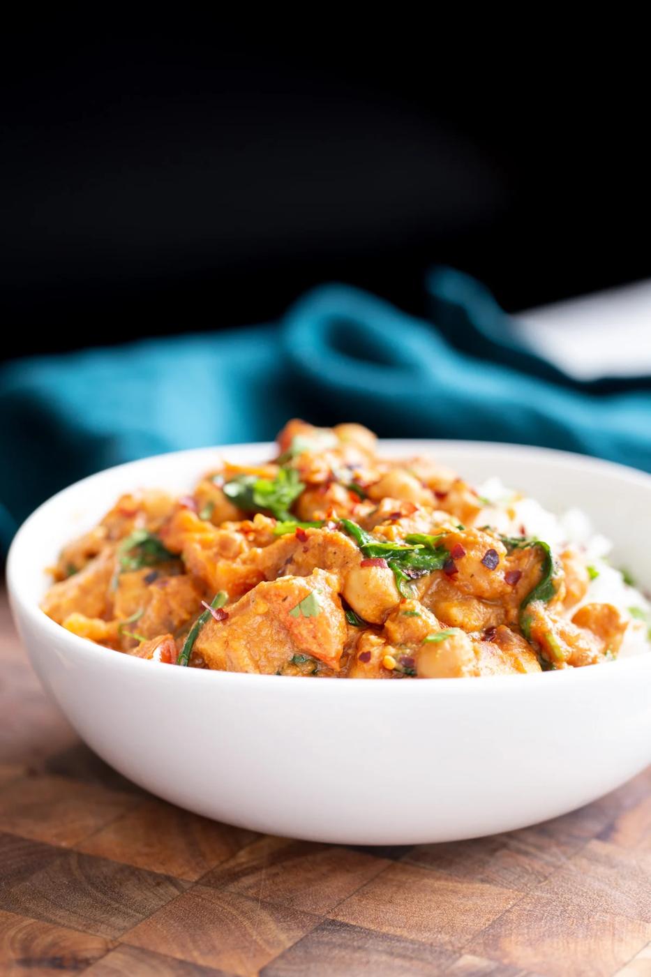 side view of a bowl of vegan chickpea sweet potato curry served over rice