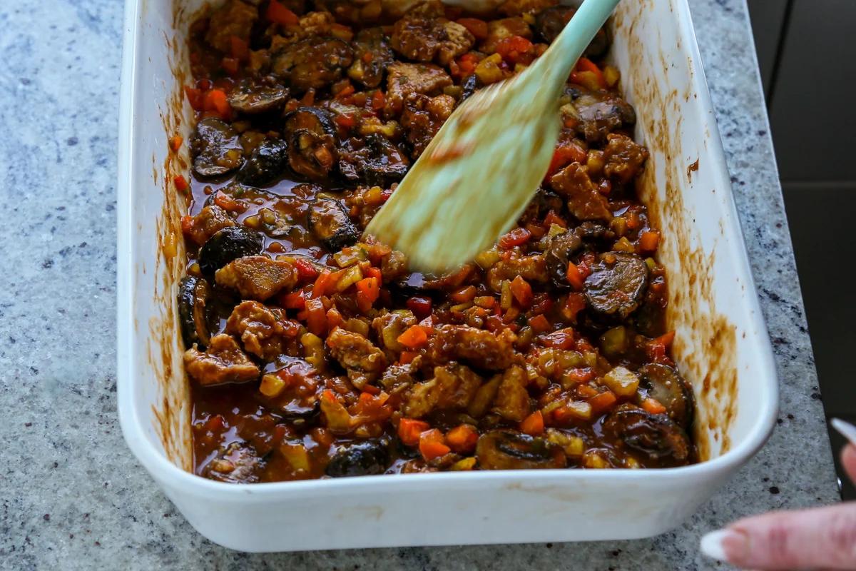 mushrooms, tofu, and peppers tossed in the sauce before baking