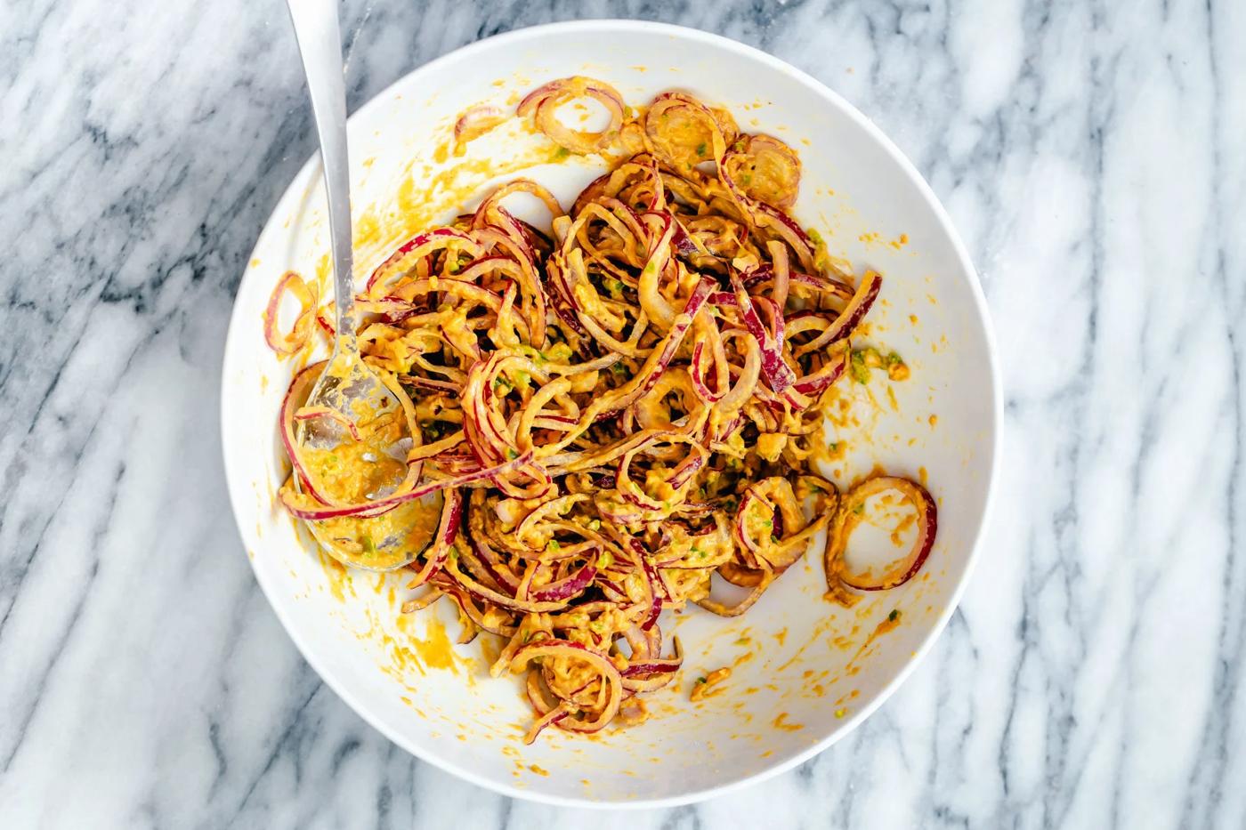 spiced onion bhaji batter in a small bowl with a spoon