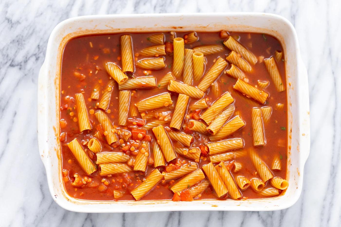 ingredients for making baked vegan rigatoni tossed in a casserole dish