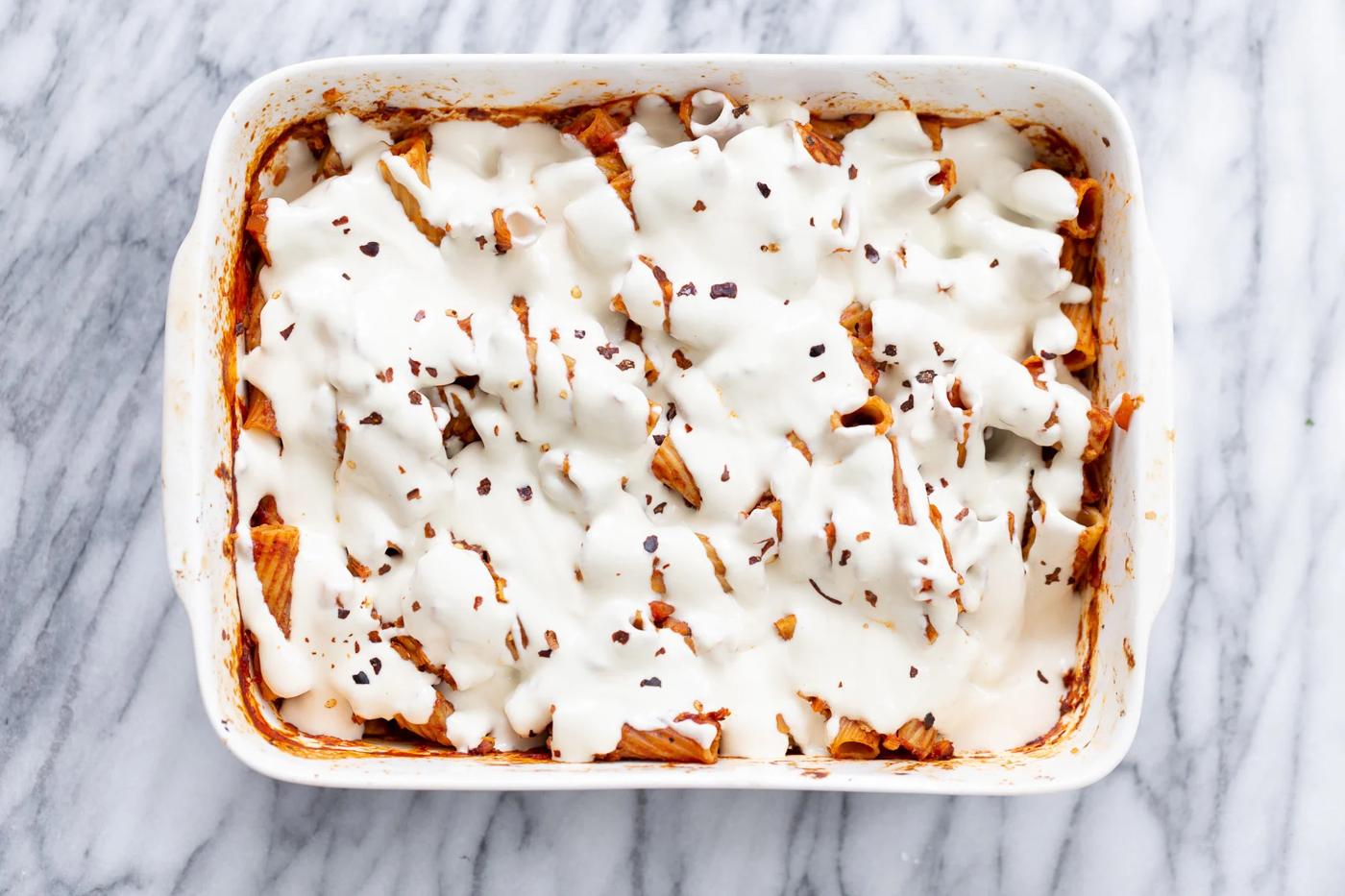 Vegan Tofu Mozzarella Cheese sauce poured on top of baked rigatoni
