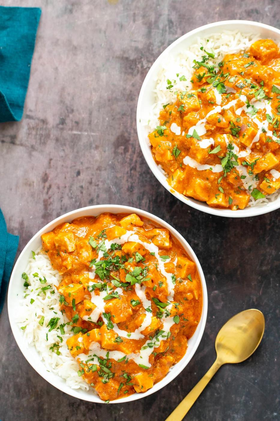 two bowl with Indian vegan baked tofu curry served over fluffy rice with a golden spoon on the side