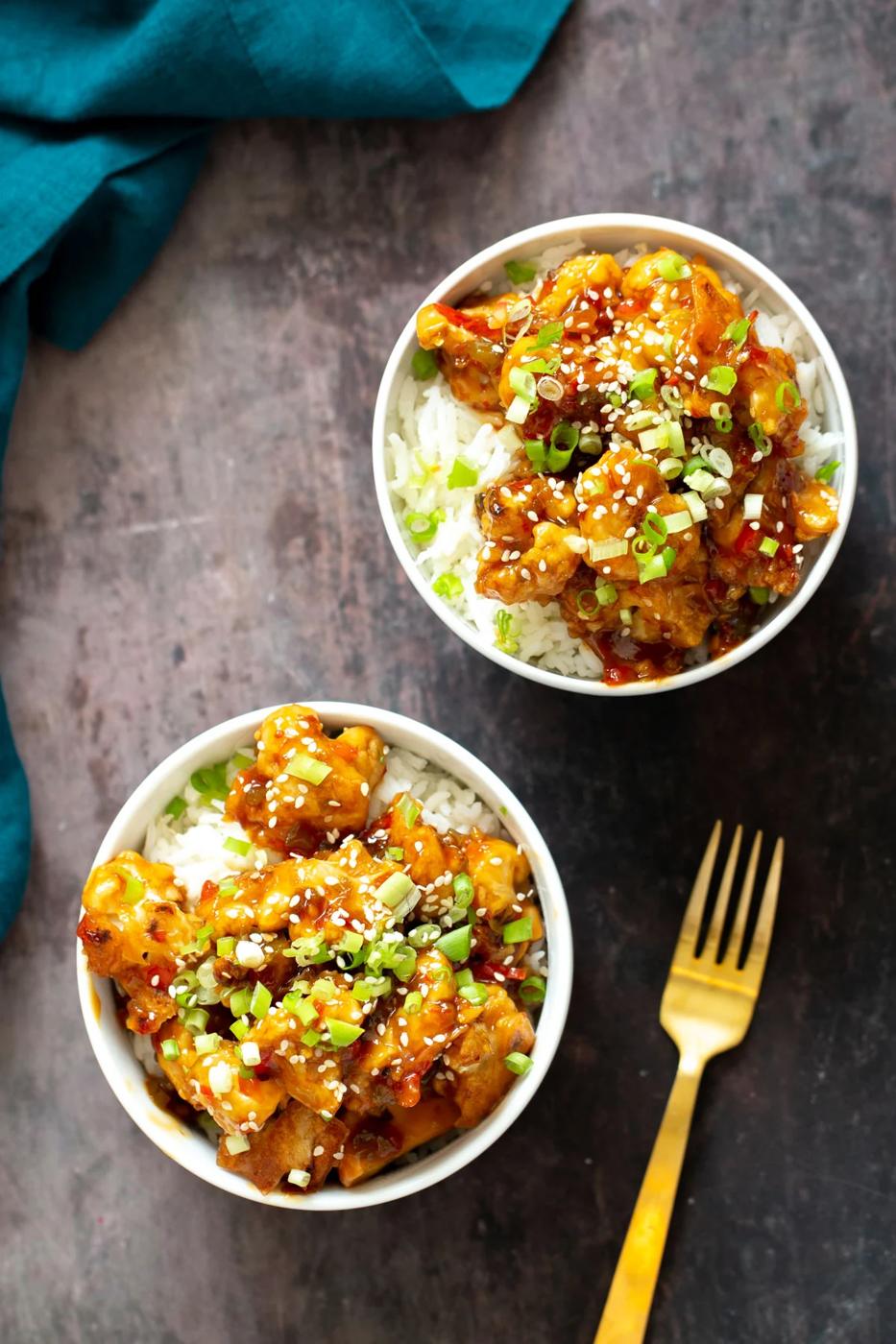 overhead shot of two servings of vegan general tso cauliflower served on rice