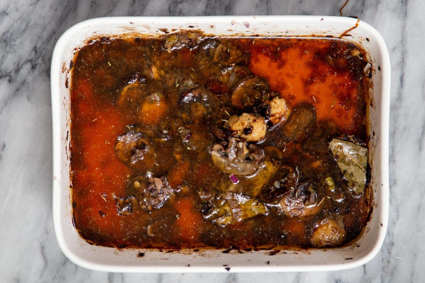 sliced baked mushrooms and broth in a casserole dish