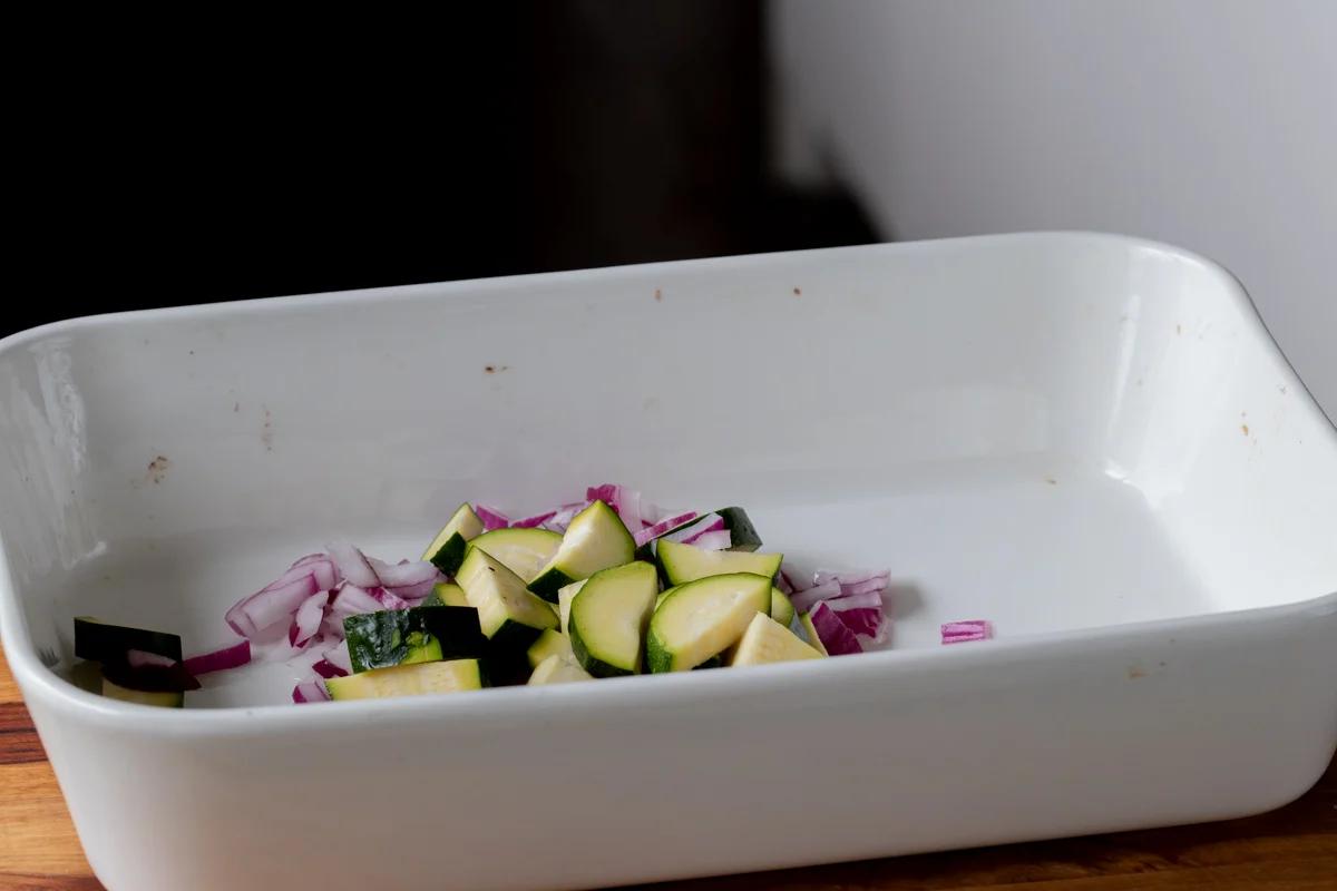 adding onion and zucchini to the pan