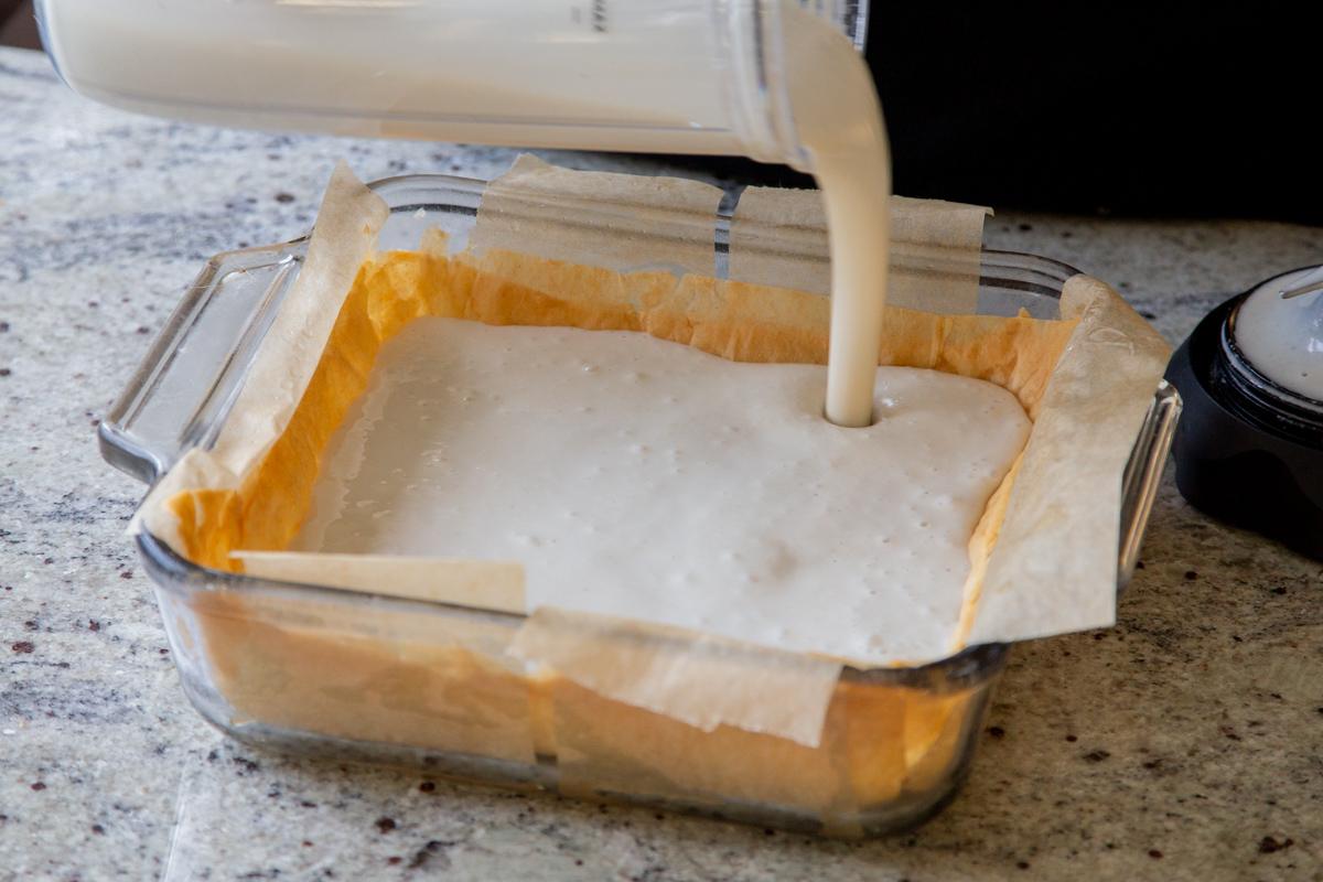 pouring cheesecake mixture into the pan