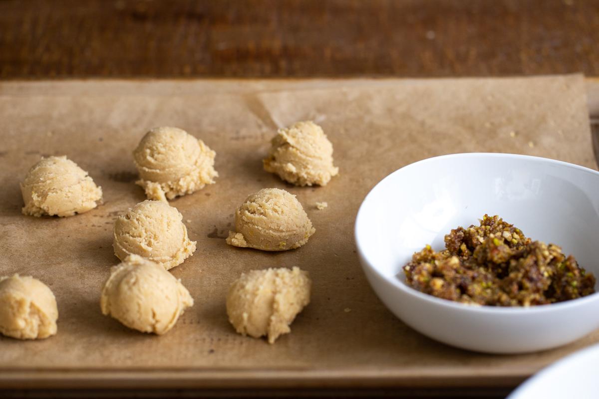 vegan cookie dough balls on a cookie sheet with parchment paper