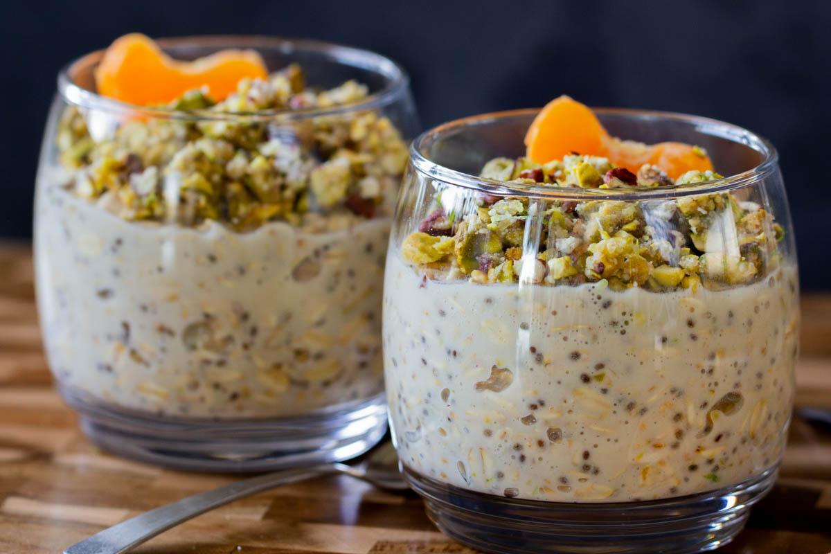 2 glasses of baklava overnight oats topped with nuts and oranges