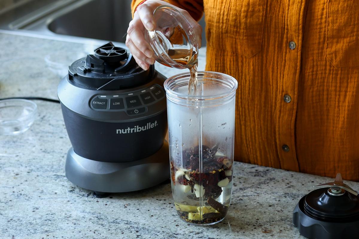adding balchao paste ingredients to the blender