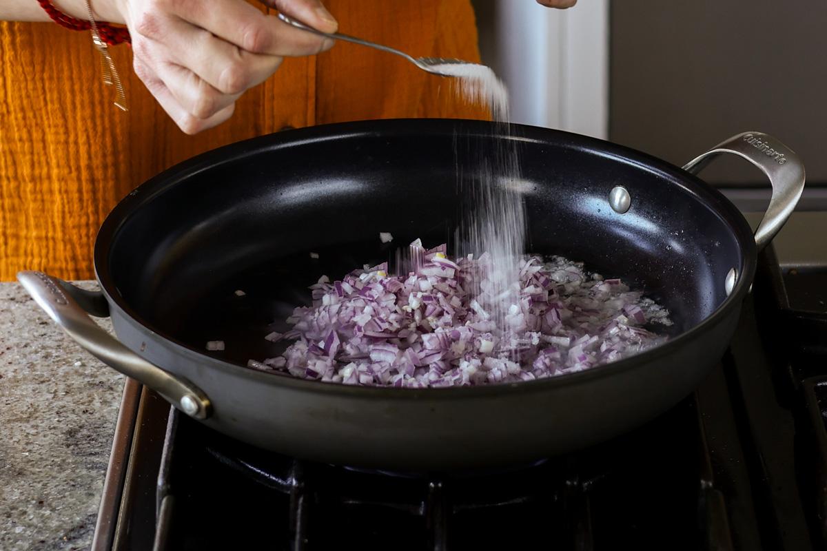 adding onion and salt to the pan
