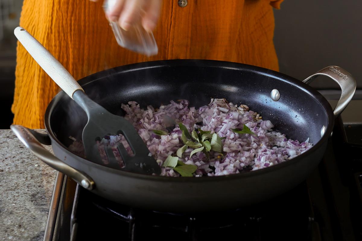 adding curry leaves to the pan