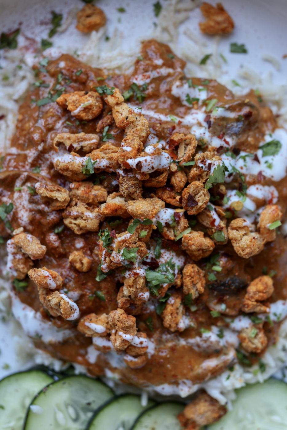 close-up of a bowl of balchao mushrooms topped with crispy beans and non-dairy yogurt