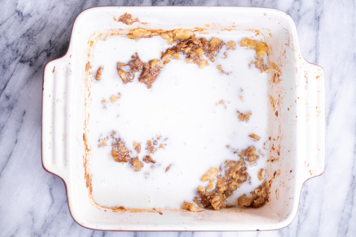 milk being added to roasted banana puree in casserole dish