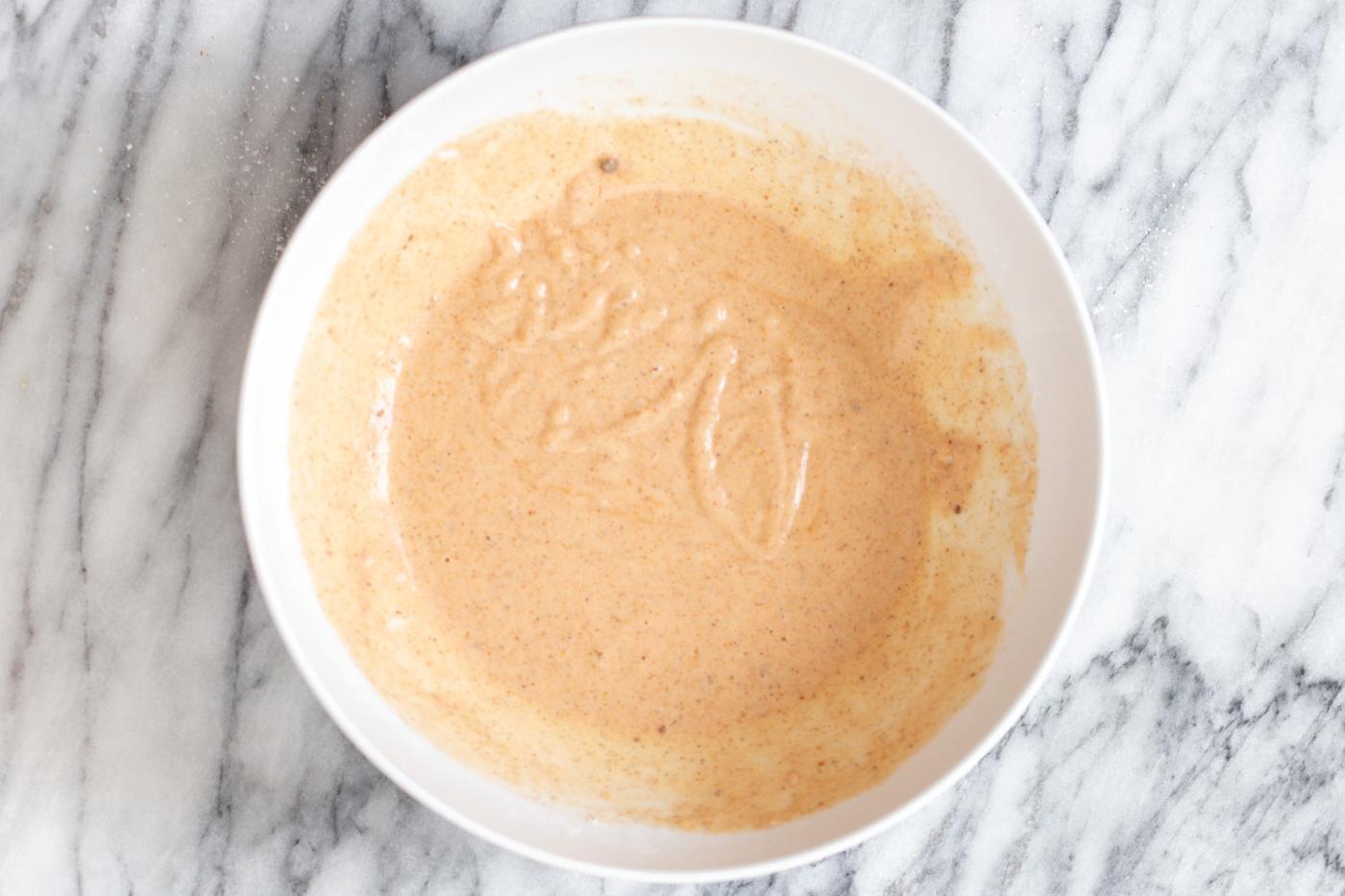 beer batter for vegan cauliflower wings in a small white bowl