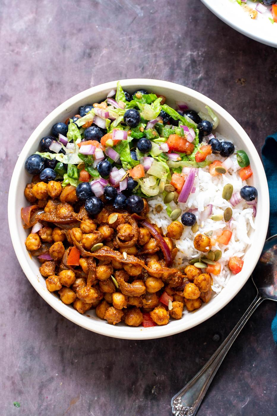 overhead shot of Berbere Chickpea bowls served with rice and a side of blueberry tomato salad
