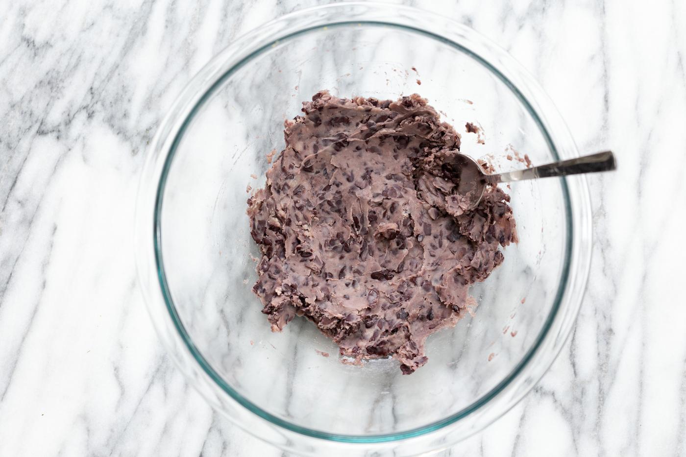 mashed black beans in a glass bowl