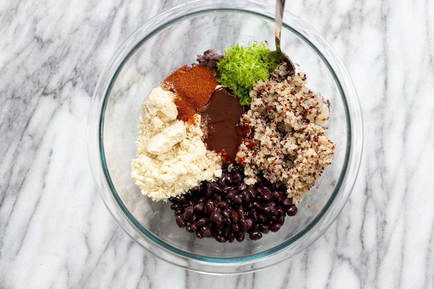 ingredients for making black bean quinoa patties gathered in a glass bowl