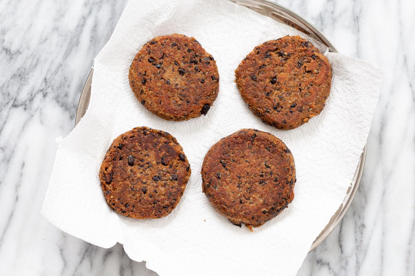 pan-fried black bean quinoa burger patties on a plate lined with paper towels