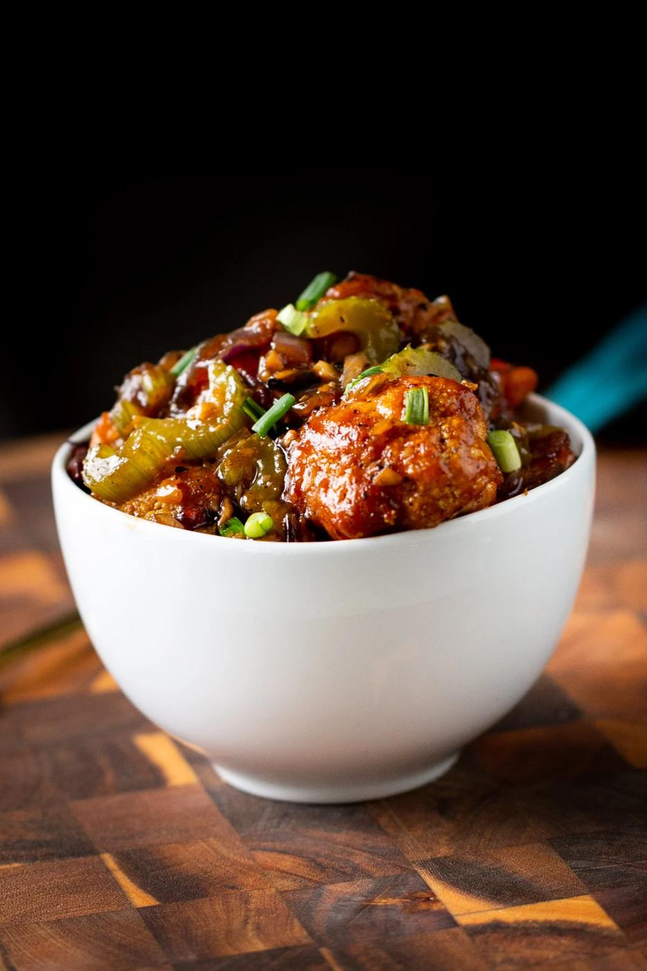 a bowl of vegan black pepper cauliflower coated in sweet spicy sauce