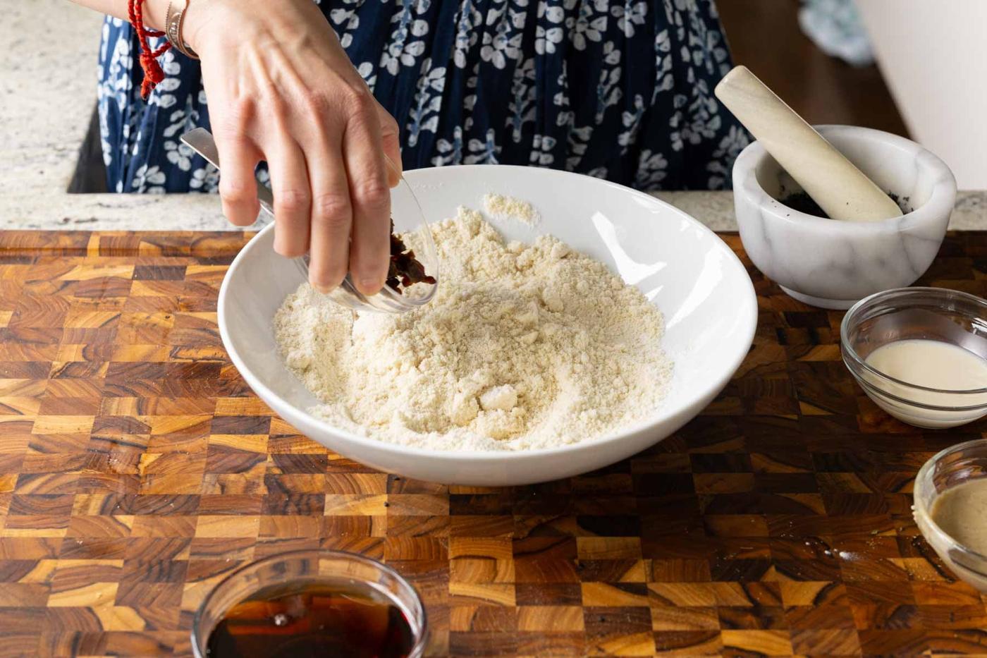 adding dates and black sesame seed to the mixed dry ingredients