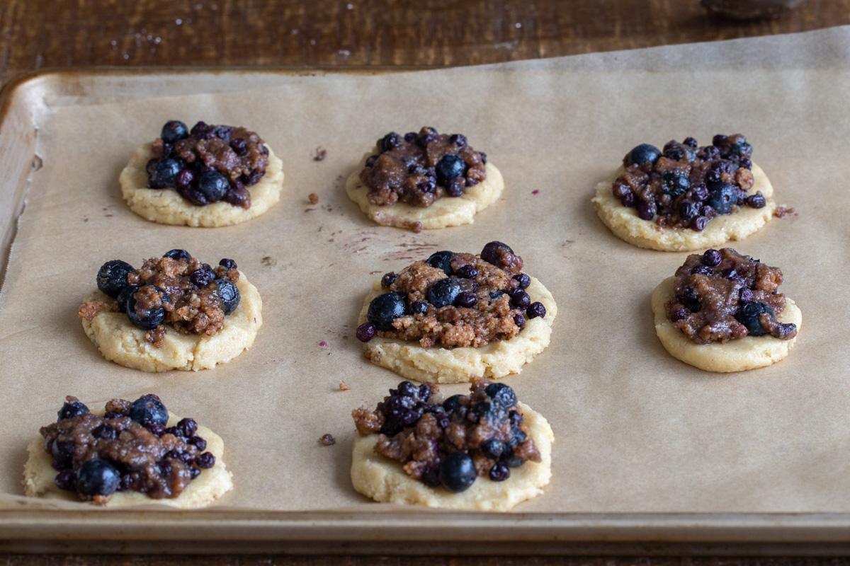 vegan blueberry muffin cookies on a lined baking sheet