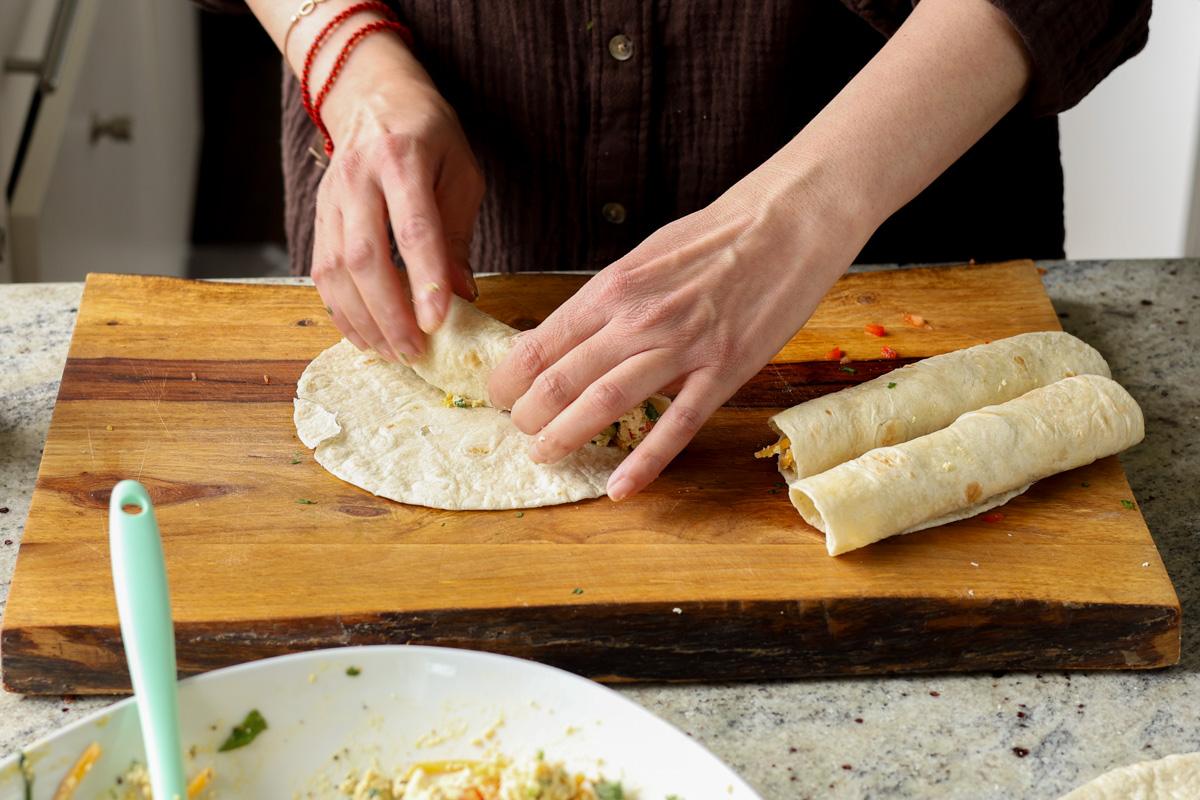 rolling the breakfast taquitos