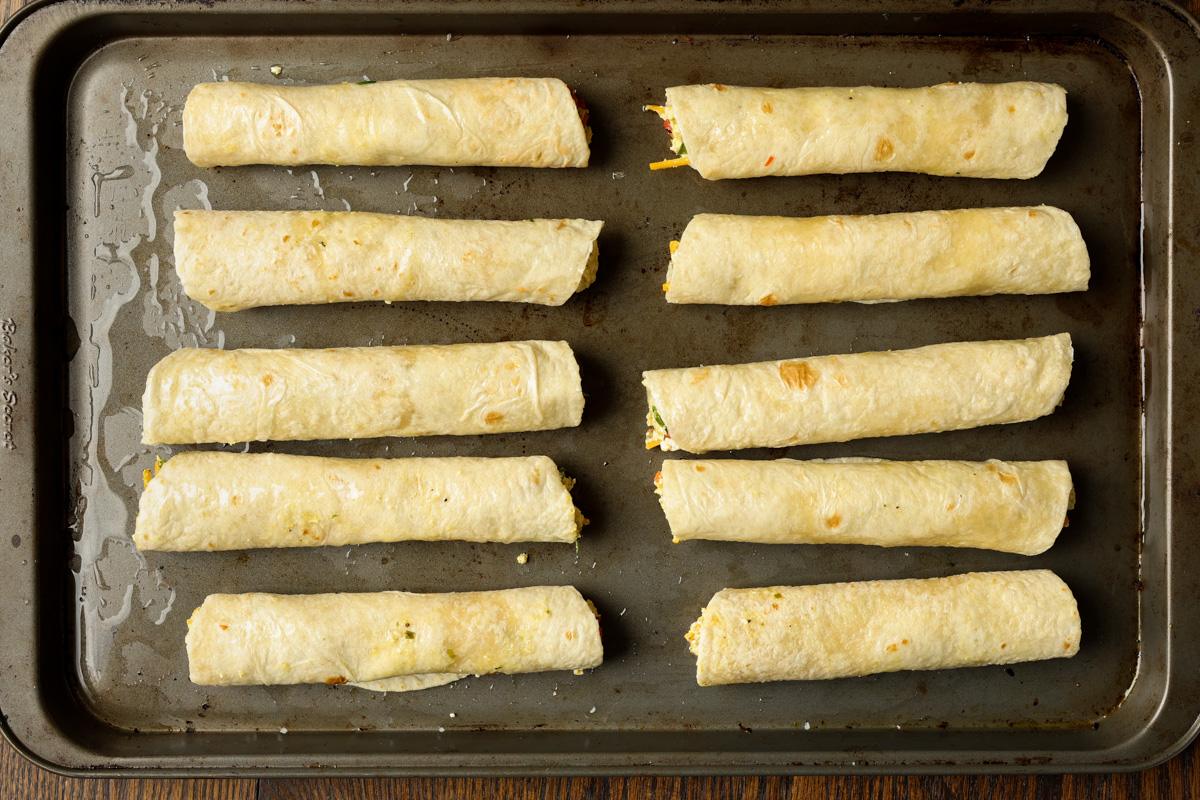 breakfast taquitos brushed with oil on the baking sheet before baking