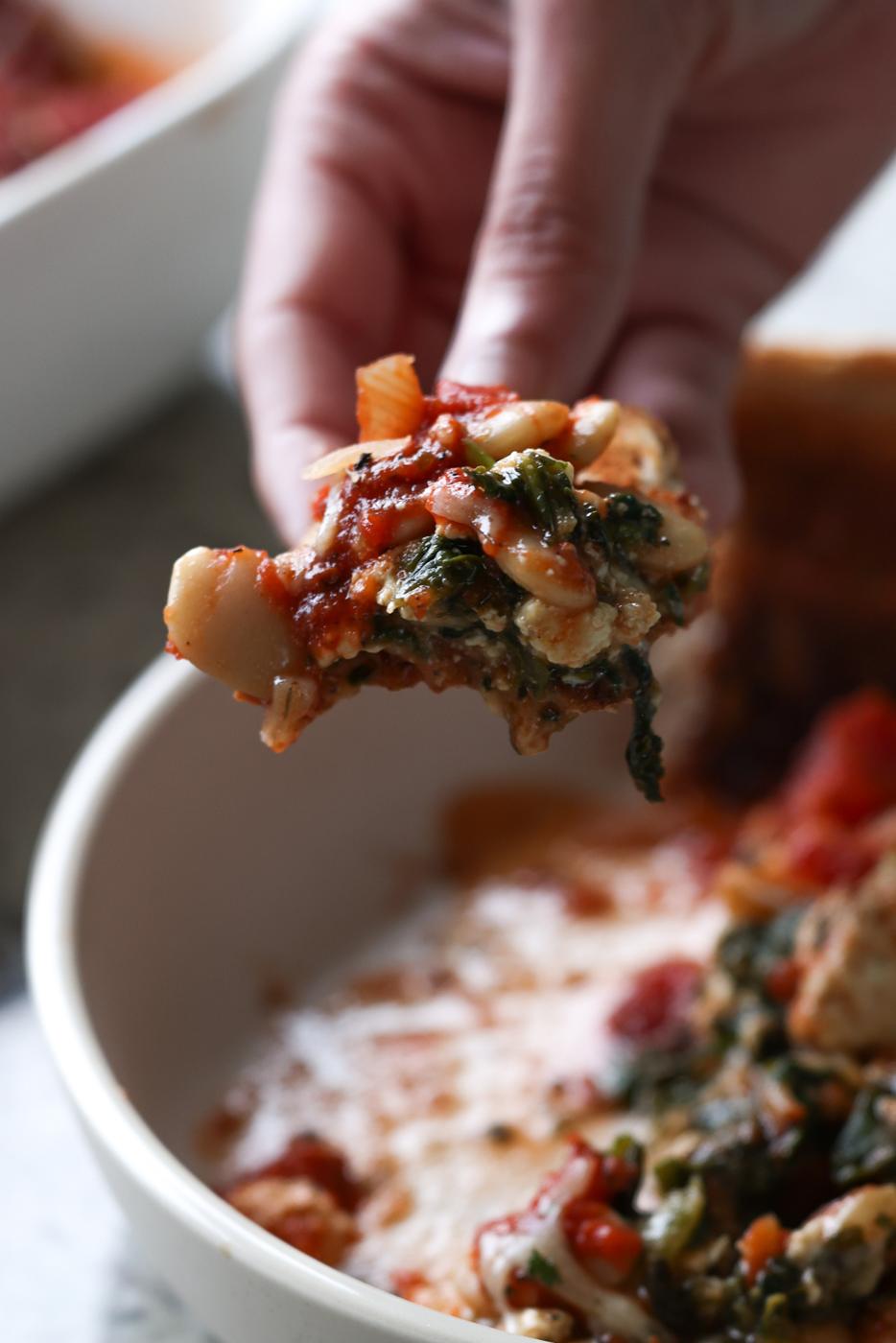 hand scooping up butterbean parmigiana