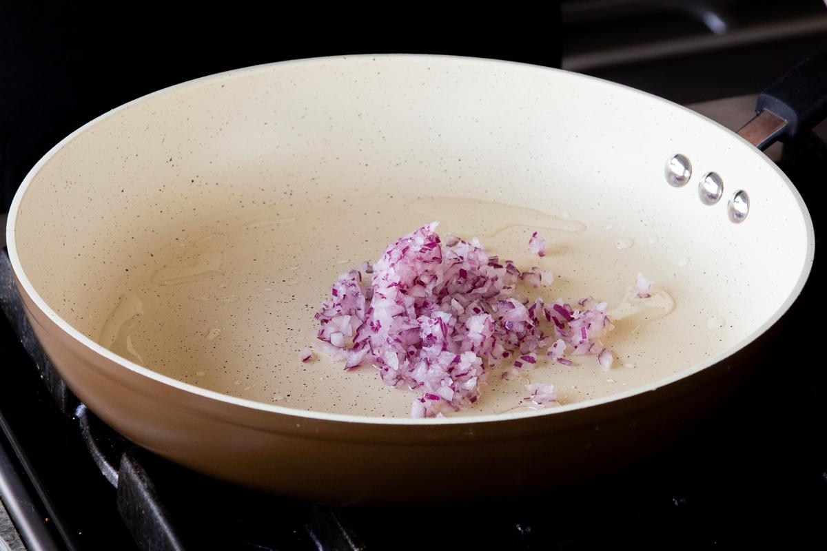 adding onion to the frying pan