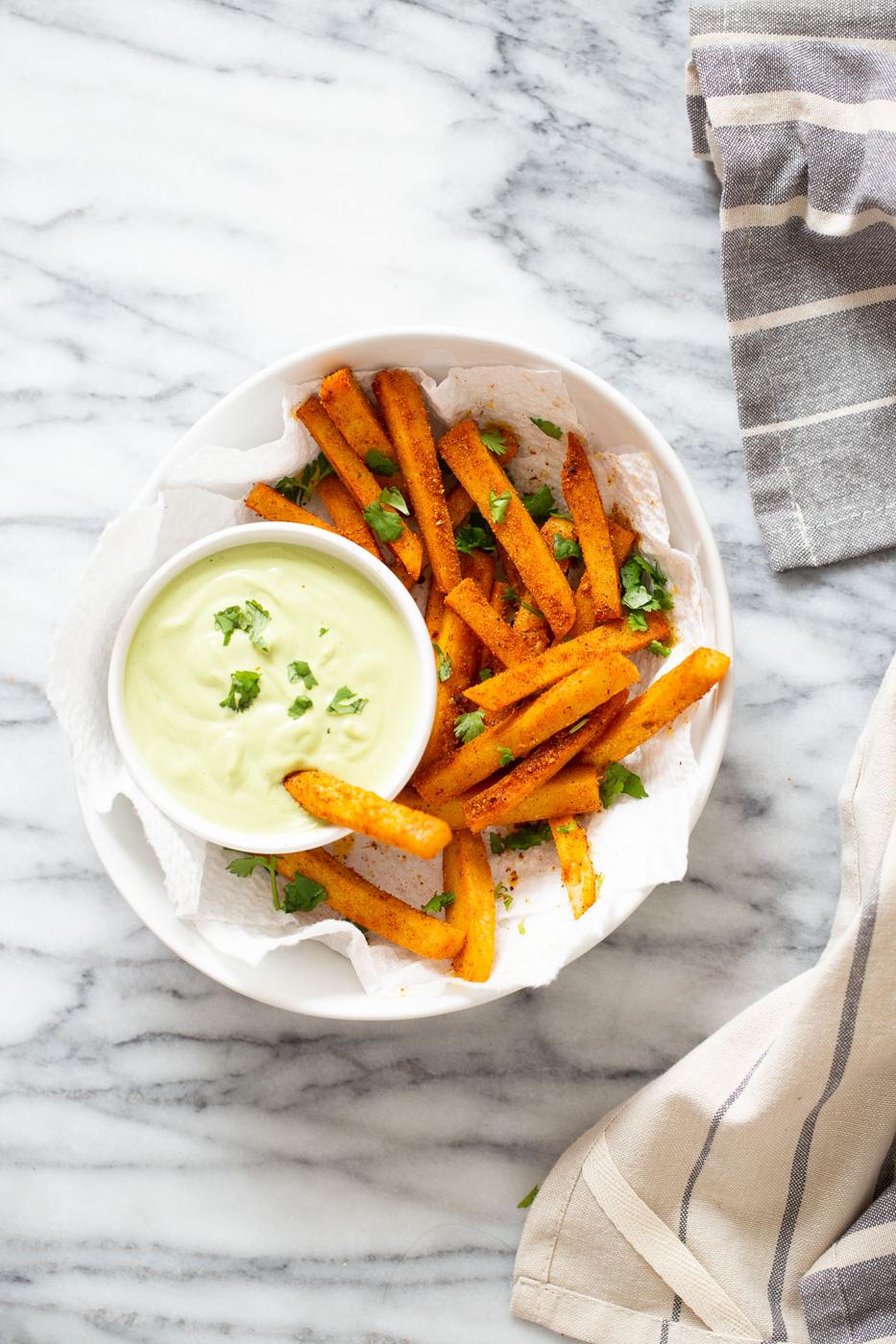 a bowl of pan-fried Cajun chickpea fries served with vegan cilantro lime dip