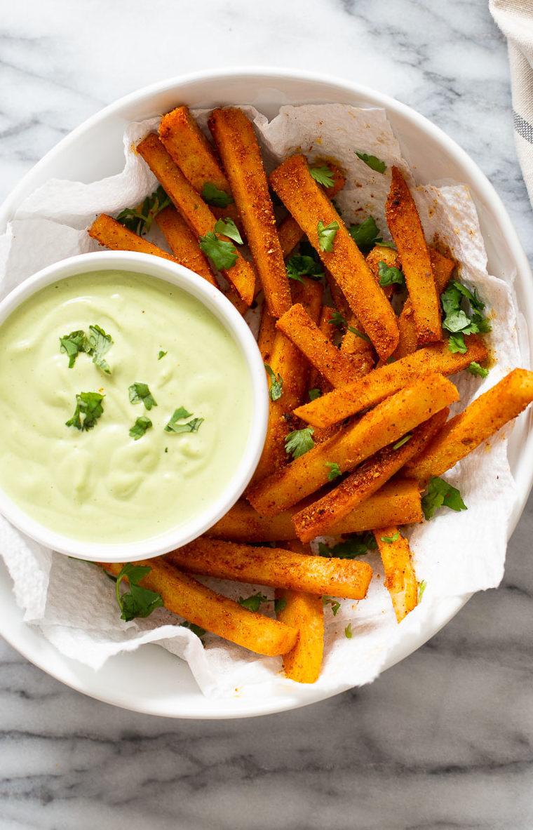 a bowl of Cajun spiced homemade chickpea flour fries served with a cilantro lime dip
