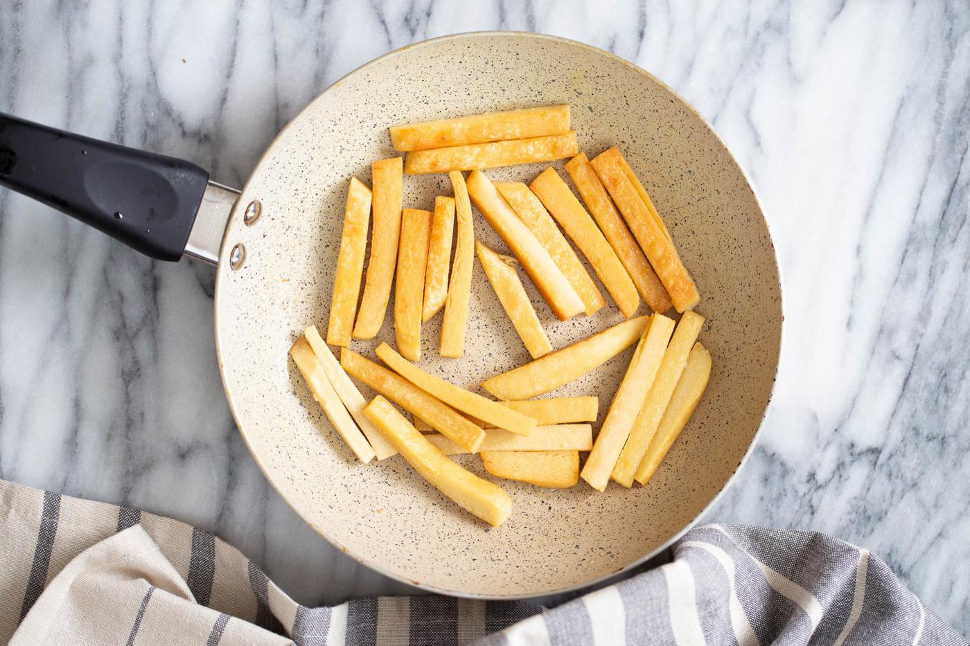 chickpea flour fries being pan-fried in a skillet