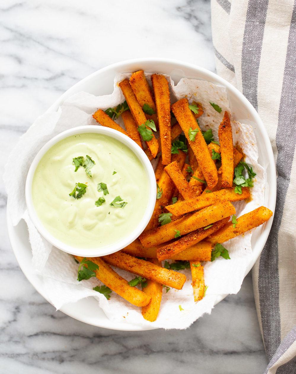 overhead shot of vegan pan fried chickpea fries tossed in Cajun seasoning and served with cilantro jalapeno lime dip