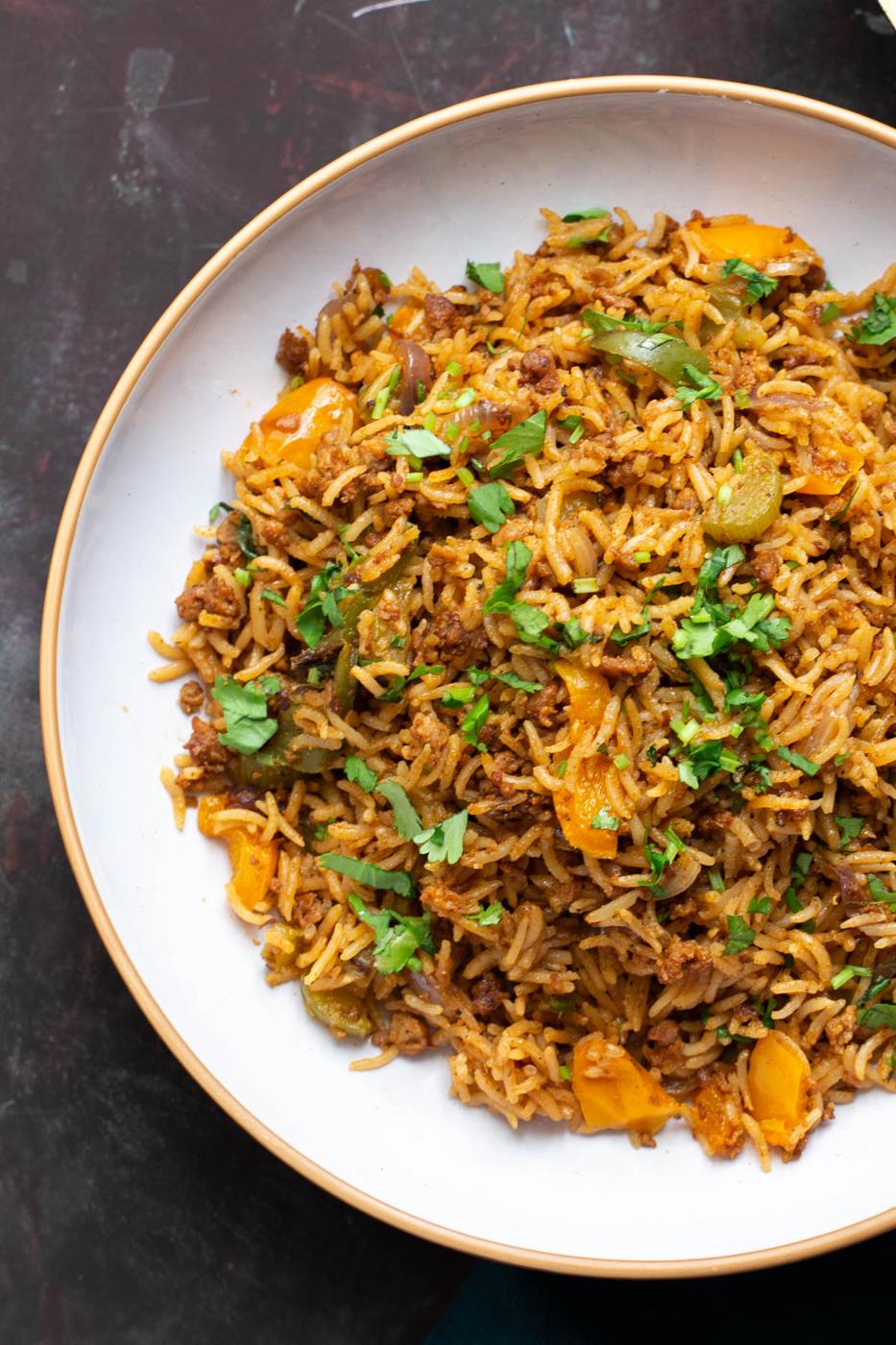 a plate of cajun dirty rice topped with cilantro