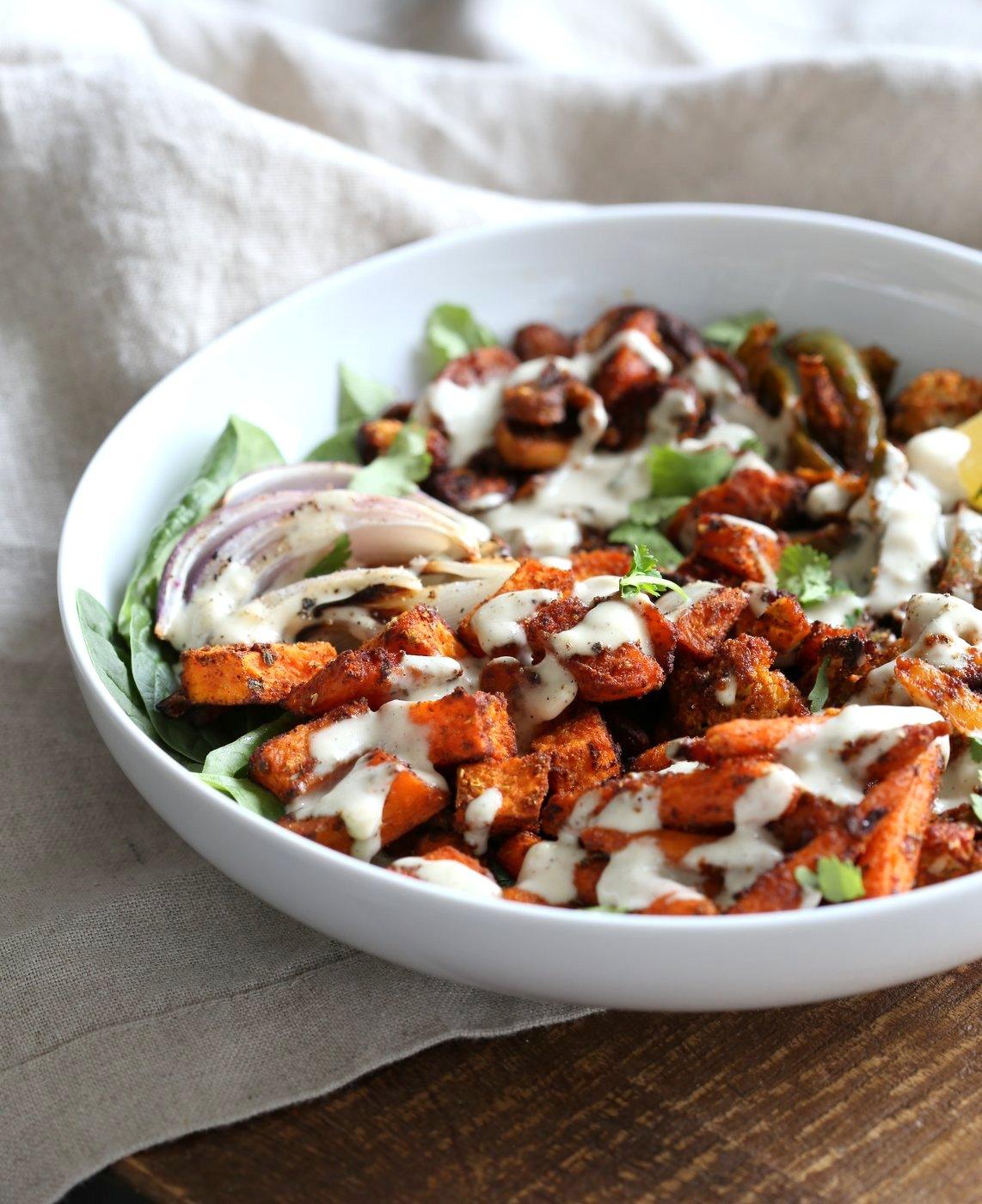 Cajun Roasted Vegetable Bowl with Garlic Sauce. Mushrooms, Cauliflower, Sweet Potato, Peppers, Onions, tossed in cajun spice blend and roasted. Serve in a bowl with crunchy greens and creamy garlic sauce or make wraps or tacos. #veganricha #Vegan #Glutenfree #Soyfree #Recipe. Can be nut-free. | VeganRicha.com