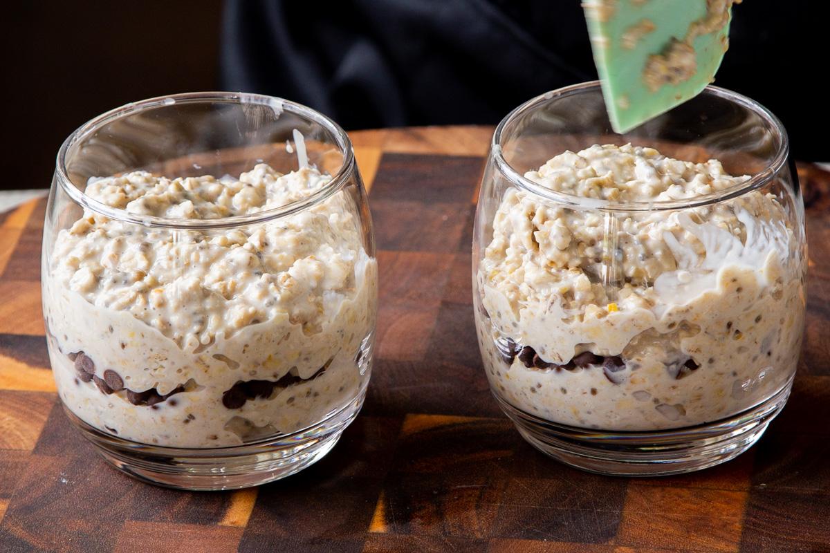 layered oat mixture with chocolate chips in the middle in glass cups