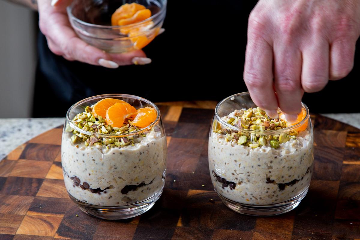 topping the cannoli oats mixture with pistachios and orange slices