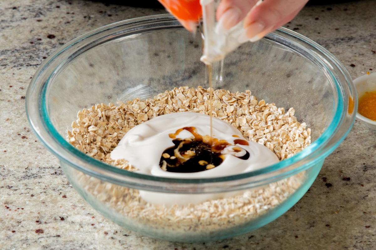 adding yogurt and maple syrup to the dry oat mixture