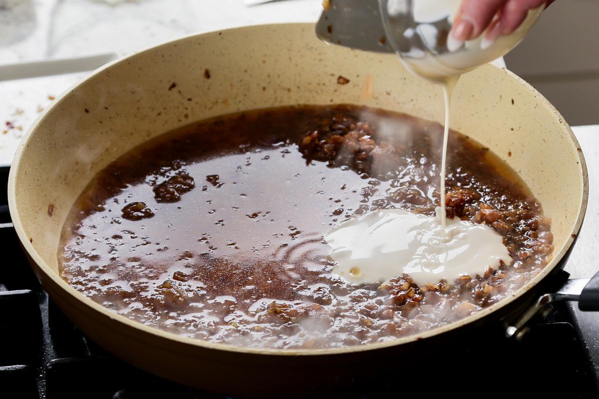 adding non-dairy yogurt to the pan of onions