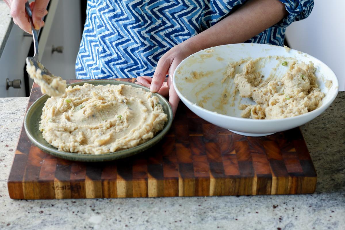 adding the mashed potatoes to the serving bowl