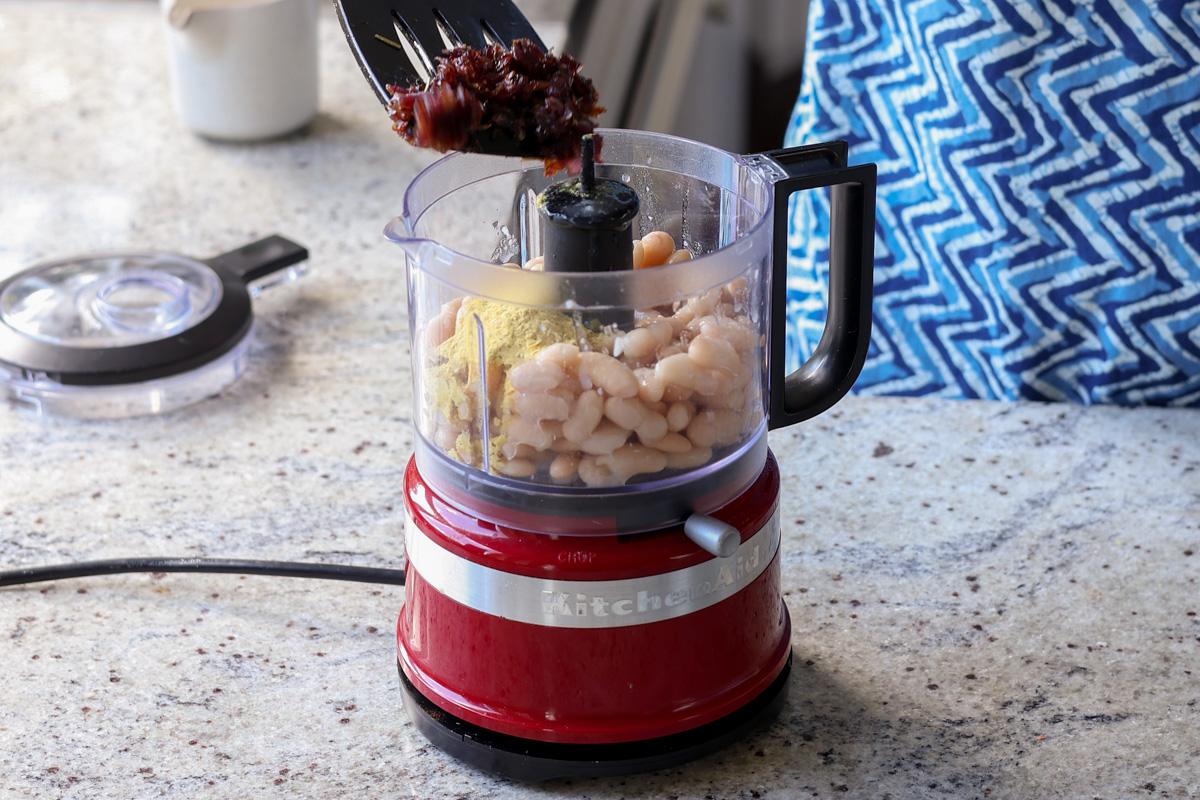 adding caramelized onion to the beans