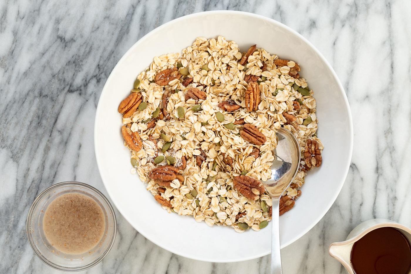 Ingredients for our Maple Pecan Granola in a white bowl