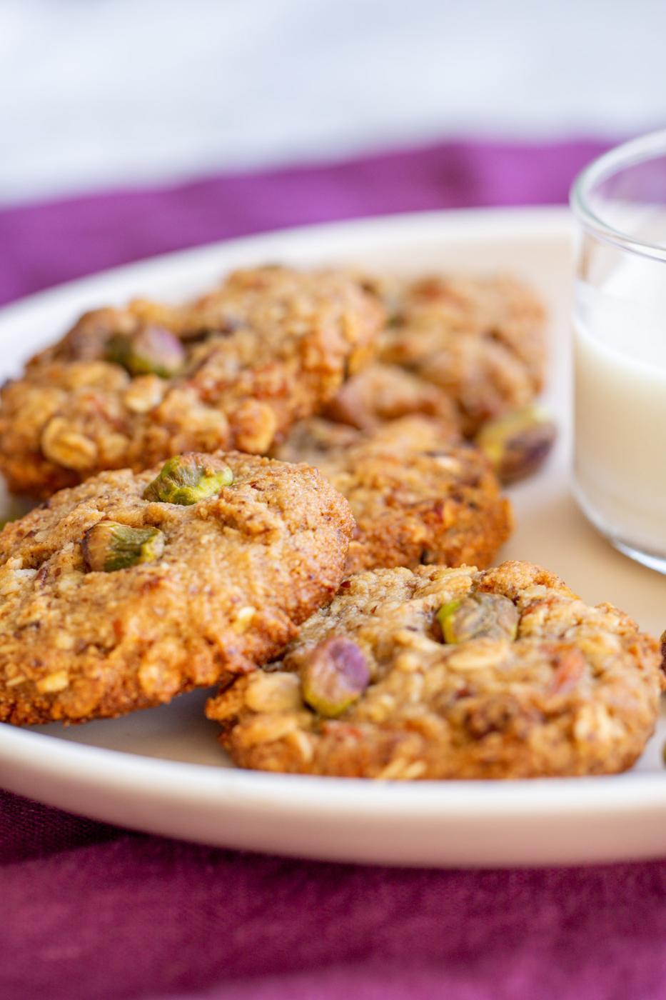 vegan carrot cake oatmeal cookies arranged around a glass of milk