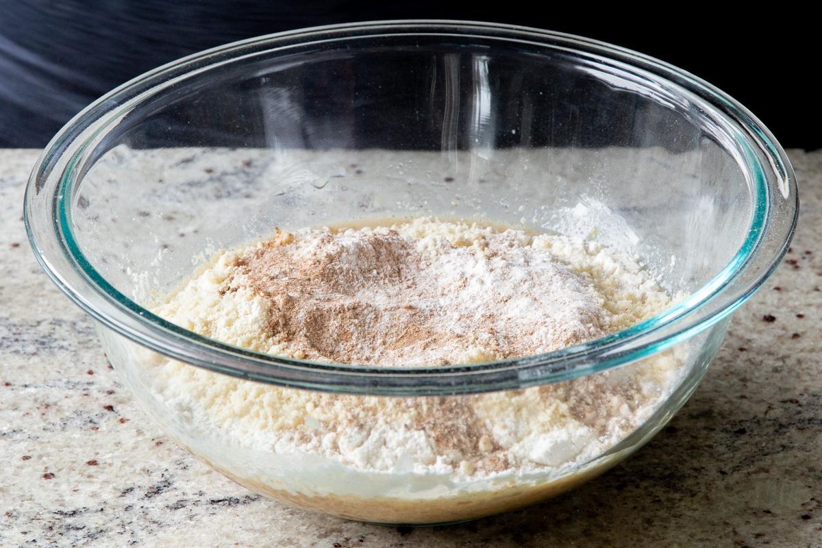 adding the remaining dry cake ingredients to the mixing bowl