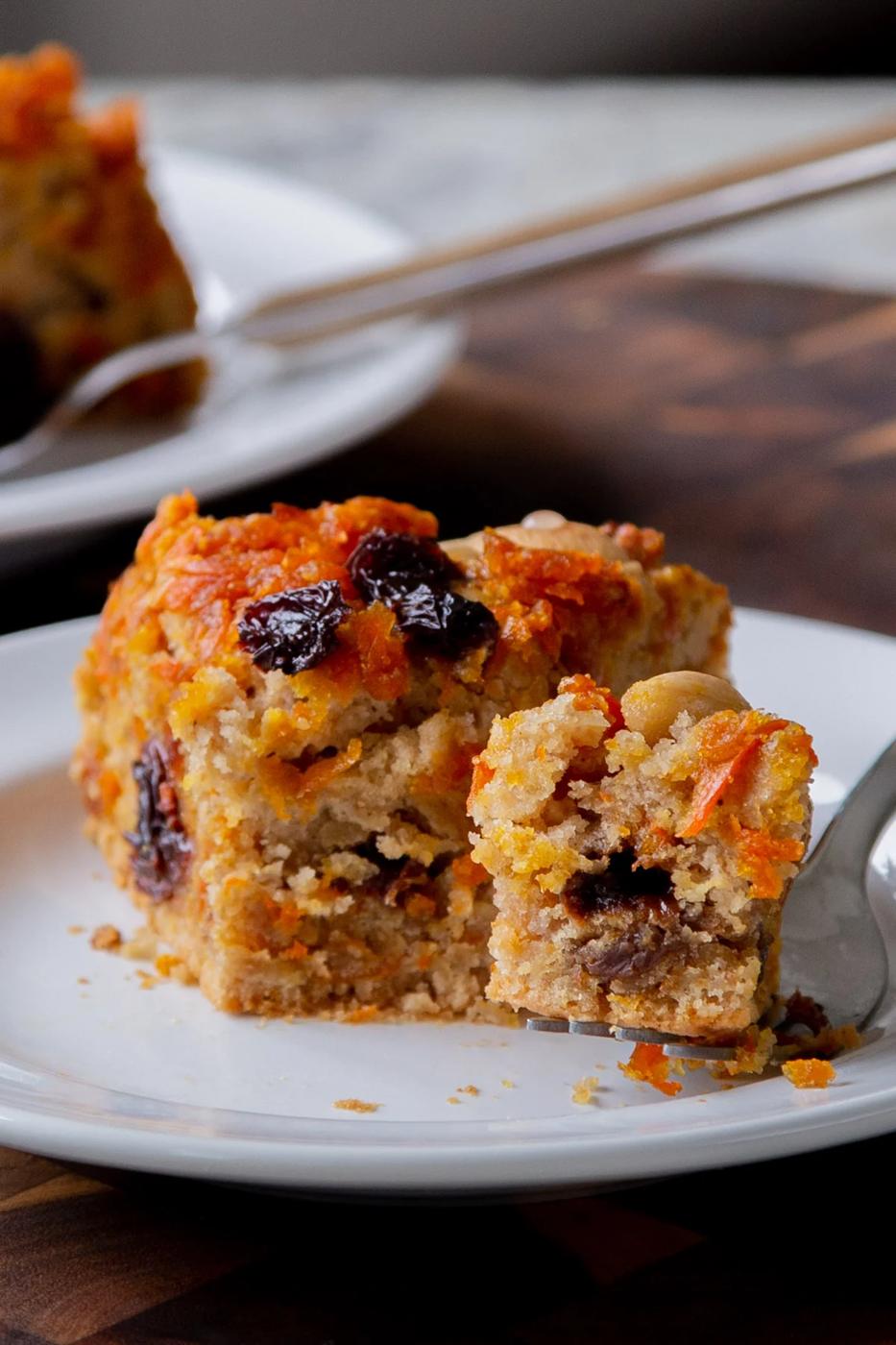 slice of carrot halwa cake on a white plate, with a bite taken out