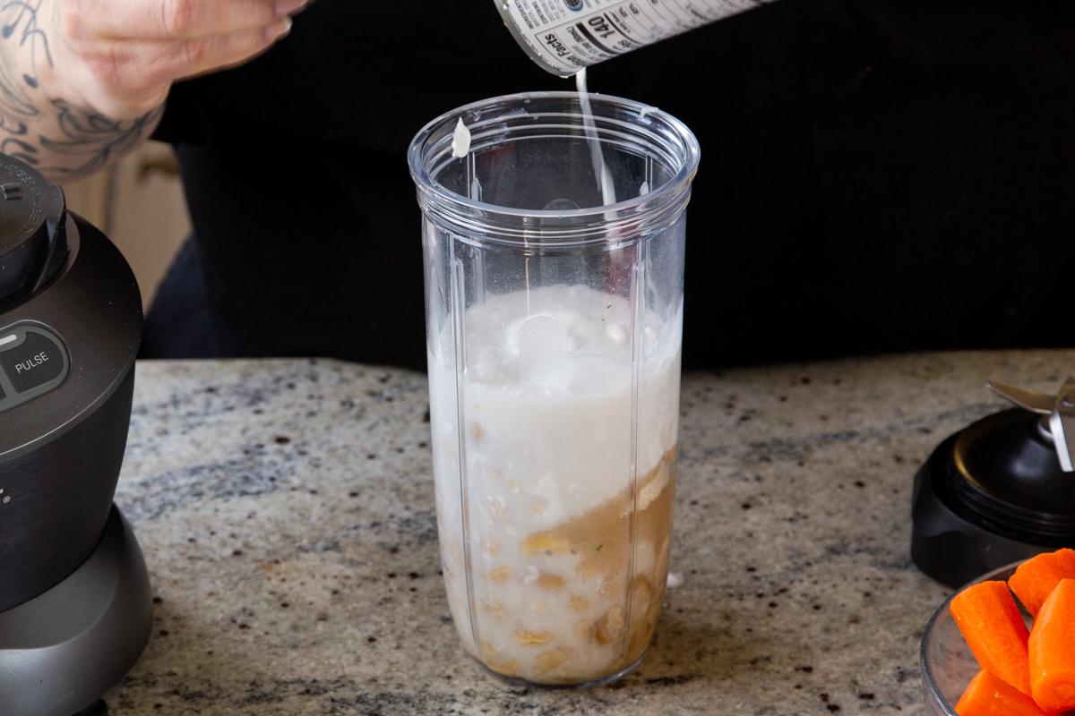 adding coconut milk to the cheesecake layer ingredients to the blender