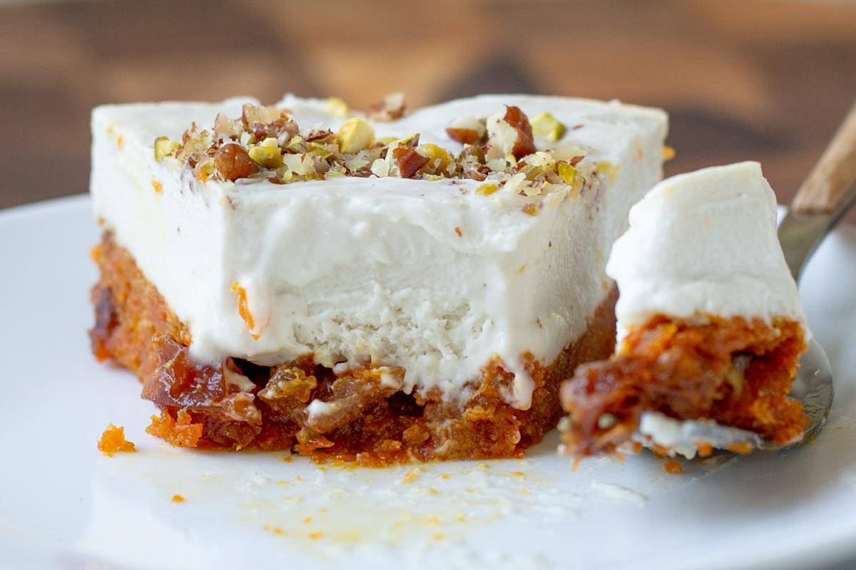 slice of carrot cake cheesecake with a bite taken out